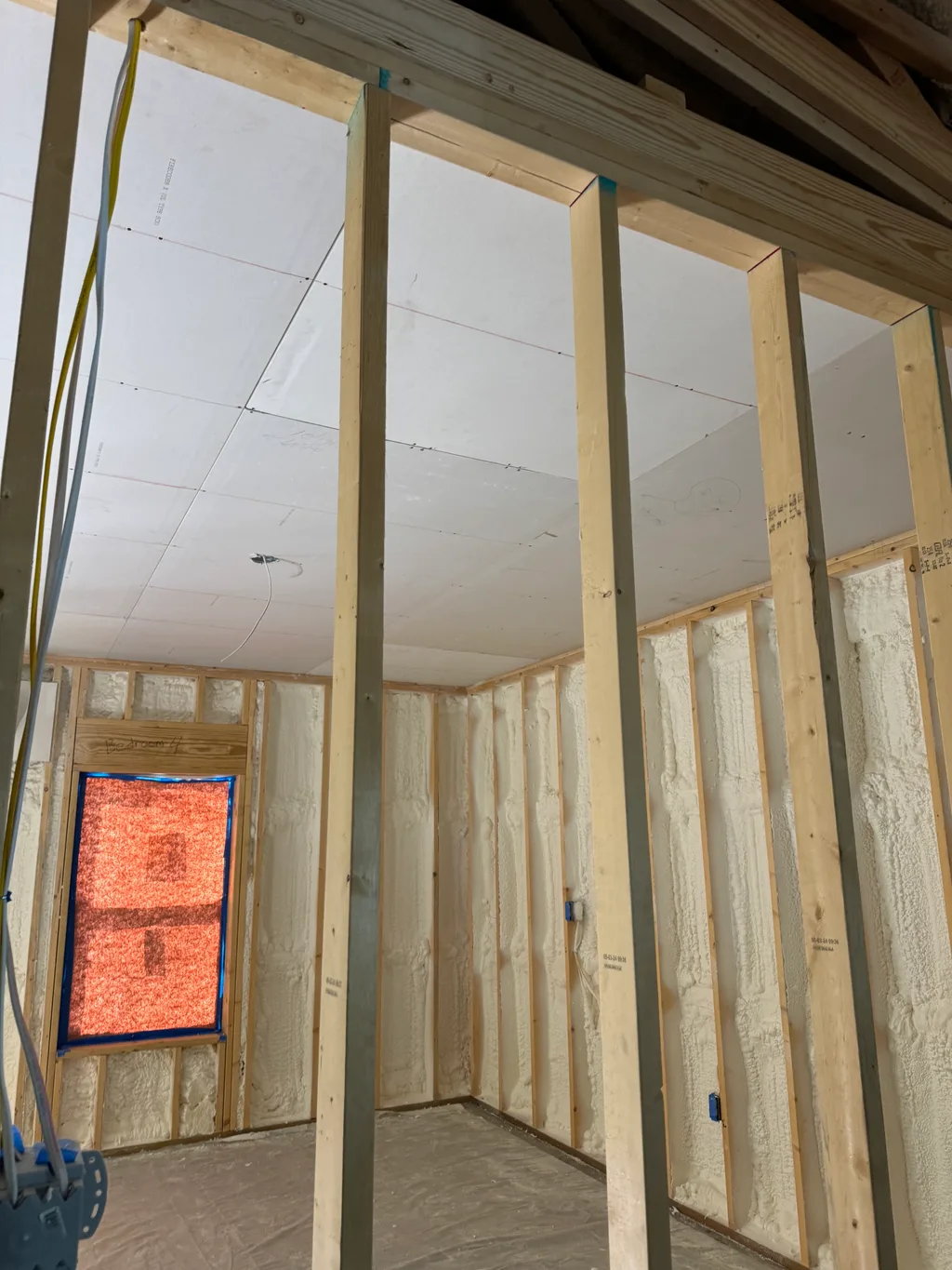 Framed room with a finished drywall ceiling, orange wall grille and a yellow strap hanging