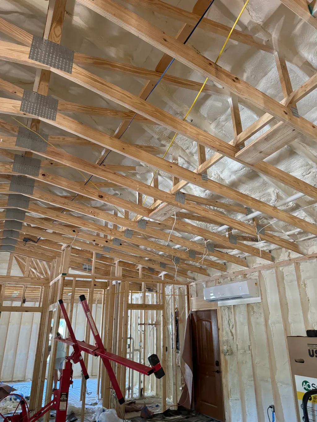 New roof trusses over a foamed ceiling with a red lifting frame standing below