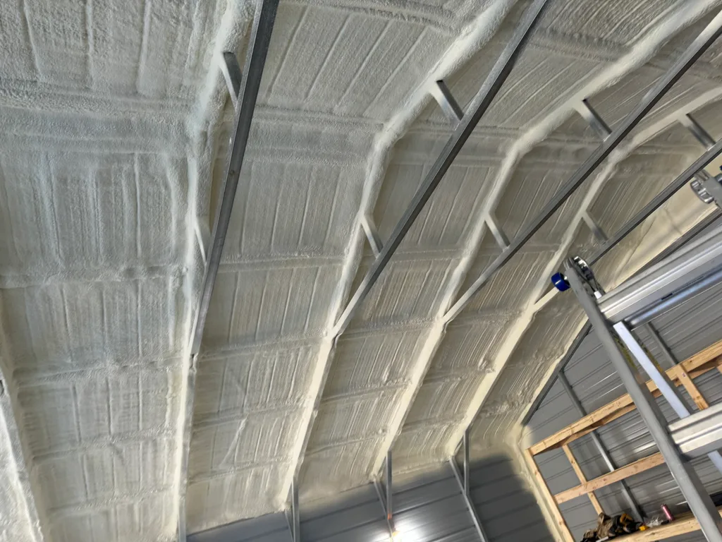 Foamed steel roof deck meeting timber framing along the far wall of a workshop